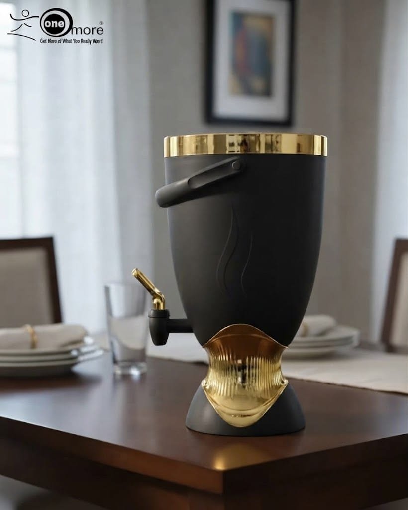 1 Matte black 5.5L beverage cooler dispenser with gold metallic accents, top handle, and dispensing tap resting on a dining table
