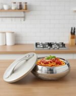Grey insulated stainless steel hotpot casserole dish with an ornate decorative lid on a modern kitchen countertop