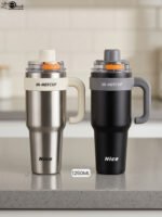 Two HI-HOTCUP 1250ml stainless steel insulated tumblers with handles in silver-cream and matte black on a kitchen counter.
