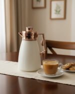 Off-white 1 Litre thermal vacuum flask featuring a rose gold handle, air-tight cap, and push-to-pour button.