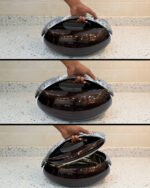 Glossy brown oval insulated hotpot casserole with chrome handle on a modern kitchen countertop.