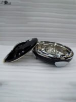 Glossy black insulated stainless steel hotpot casserole with silver chrome accents and lid open on a kitchen countertop.