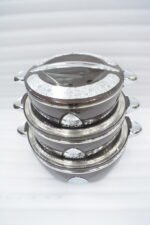 3-piece stacked luxury insulated hot pot casserole set in dark brown with silver chrome trim on a dining table setup.