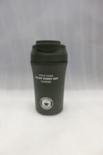 Four 450ml insulated travel coffee mugs in navy blue, olive green, cream, and matte black on a marble kitchen countertop