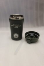 Four 450ml insulated travel coffee mugs in navy blue, olive green, cream, and matte black on a marble kitchen countertop
