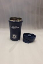 Four 450ml insulated travel coffee mugs in navy blue, olive green, cream, and matte black on a marble kitchen countertop