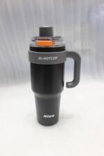 Two HI-HOTCUP 1250ml stainless steel insulated tumblers with handles in silver-cream and matte black on a kitchen counter.