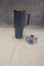 Six 1180ml leopard print insulated travel tumblers with handles and straws displayed in various colors on a kitchen counter.