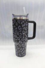 Six 1180ml leopard print insulated travel tumblers with handles and straws displayed in various colors on a kitchen counter.