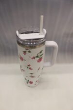 Four 1180ml floral printed insulated tumblers with handles and reusable straws standing on a kitchen counter.