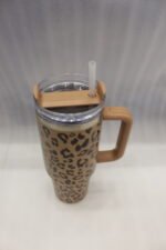 Six 1180ml leopard print insulated travel tumblers with handles and straws displayed in various colors on a kitchen counter.