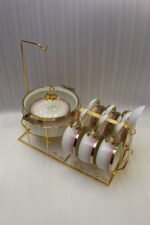 Pink and white gradient ceramic soup tureen set with gold rims, suspended glass lid on a gold frame, buffet burner warmer stand, matching soup cups, saucers, and ceramic spoons.