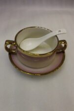 Pink and white gradient ceramic soup tureen set with gold rims, suspended glass lid on a gold frame, buffet burner warmer stand, matching soup cups, saucers, and ceramic spoons.