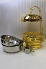 Luxury royal gold chafing dish with intricate lattice stand and suspended dome lid on a kitchen countertop.