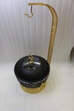 One More luxury matte black and gold hanging lid buffet chafing dish with stainless steel pan on a marble kitchen counter.
