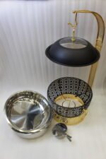 One More luxury matte black and gold hanging lid buffet chafing dish with stainless steel pan on a marble kitchen counter.