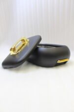 Three matte black insulated hot pot food containers with gold lid handles resting on a marble kitchen countertop.