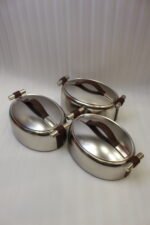 Set of three brushed stainless steel insulated hot pots with leather-look handles on a wooden table