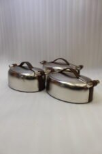 Set of three brushed stainless steel insulated hot pots with leather-look handles on a wooden table