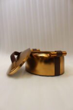 3-piece luxury brushed gold oval insulated hot pot set with leather accent handles displayed on a wooden dining table