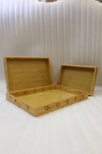Three-piece natural wooden serving tray set with decorative floral side cutouts displayed on a marble kitchen counter.