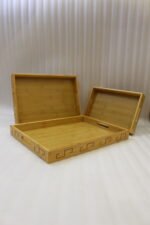 3 piece natural wooden serving tray set with cut-out side handles and engraved geometric border design displayed on a marble kitchen counter