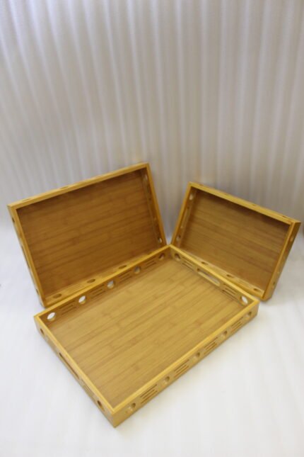 Set of 3 natural wooden serving trays with side cutout designs and built-in handles on a marble kitchen countertop