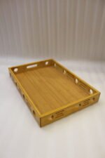 Set of 3 natural wooden serving trays with side cutout designs and built-in handles on a marble kitchen countertop