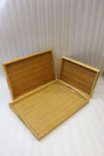3 piece rectangular wooden serving tray set with built-in cutout handles displayed on a marble kitchen countertop