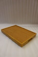 3 piece rectangular wooden serving tray set with built-in cutout handles displayed on a marble kitchen countertop