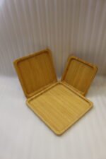 Set of 3 natural wooden square serving trays in small, medium, and large sizes displayed on a marble kitchen countertop.