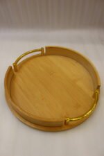Set of 3 nesting round bamboo wooden serving trays with stylish gold metal handles on a white countertop.