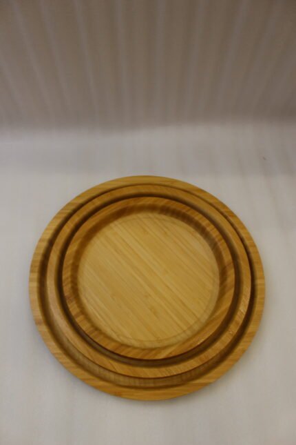 3-piece nested round wooden serving tray set made of natural bamboo displayed on a marble kitchen countertop