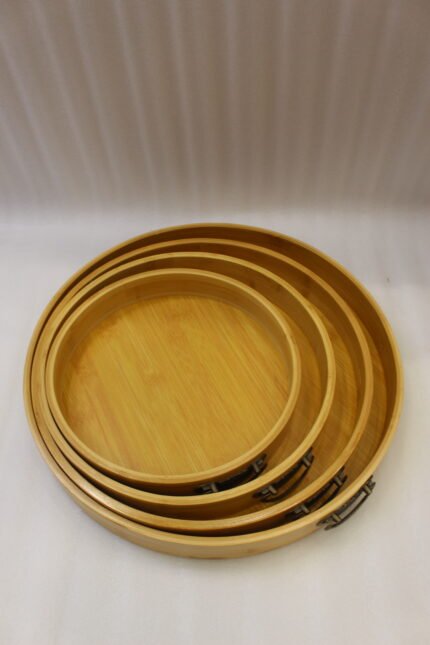 4-piece round wooden nesting serving tray set with built-in cut-out handles stacked on a white kitchen countertop