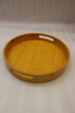 4-piece round wooden nesting serving tray set with built-in cut-out handles stacked on a white kitchen countertop