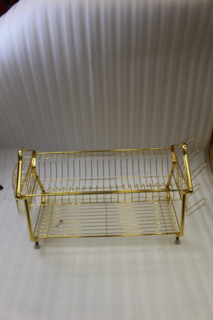 2 tier luxury gold metal dish drying rack with utensil basket, glass holder hooks, and clear drip tray on a kitchen countertop next to a faucet.