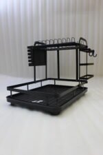 Modern 2-tier black metal dish drying rack with side utensil caddy and bottom drain tray on a kitchen countertop.
