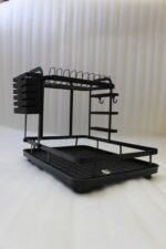 Modern 2-tier black metal dish drying rack with side utensil caddy and bottom drain tray on a kitchen countertop.