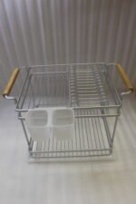 Two-tier silver dish drying rack with wooden side handles, hanging utensil holders, and a plastic drip tray on a kitchen countertop.