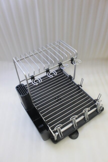 Modern 2-tier stainless steel dish drying rack with integrated knife block, utensil caddy, cup holders, and drainage tray on a granite countertop next to the sink.