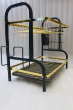 Two-tier gold and black metal dish drying rack with removable drip tray and utensil holder on a white marble kitchen countertop.