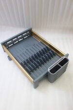 Modern grey and gold dish drying rack placed next to a sink on a kitchen countertop.