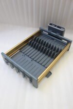 Modern grey and gold dish drying rack placed next to a sink on a kitchen countertop.