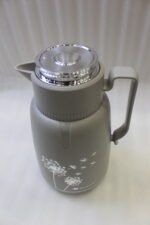 Two 2-liter MIXFF insulated thermal vacuum flasks in matte grey and beige with silver dandelion prints on a kitchen countertop.