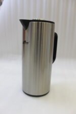 One More 1 Liter brushed stainless steel thermal vacuum flask with a black handle and pour spout on a kitchen countertop.