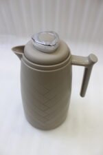 Three One More 1 Liter modern thermal vacuum flasks in charcoal grey, taupe beige, and white standing on a white kitchen marble countertop.