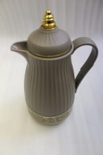 Three ONE MORE 1-liter ribbed luxury vacuum flasks in black, cream, and taupe with gold top finials on a marble kitchen counter.