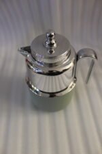 Two One More 1 Liter thermal vacuum coffee carafes in brown and sage green with ribbed bases and polished stainless steel tops on a kitchen counter.