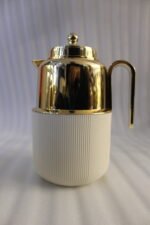 Three One More 1 liter luxury thermal vacuum flasks in black, white, and grey with polished gold tops on a marble kitchen countertop.