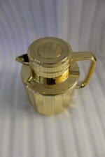 One More 1 liter luxury polished gold vacuum insulated flask with a fluted ribbed design on a marble countertop.